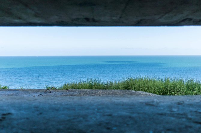Normandy D-Day Small-Group Day Trip with Omaha Beach, Cemetery & Cider Tasting - Pointe du Hoc cliffs and bomb craters: the view that explains the mission